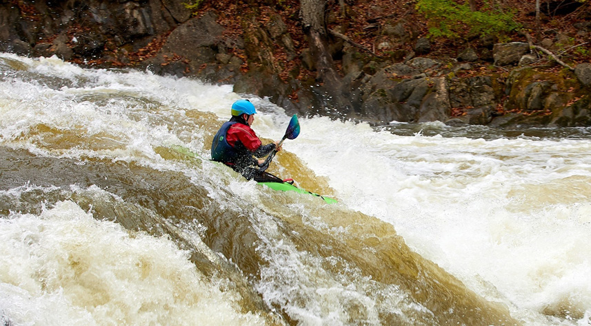 Jesse on flume, bulls bridge. Green kayak with blue helmet on big water